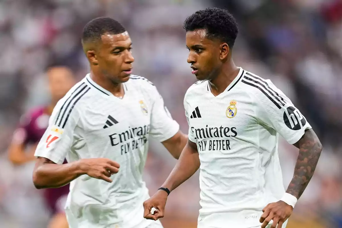 Two Real Madrid players in white uniforms run on the field during a match. Two Real Madrid players in white uniforms run on the field during a match.