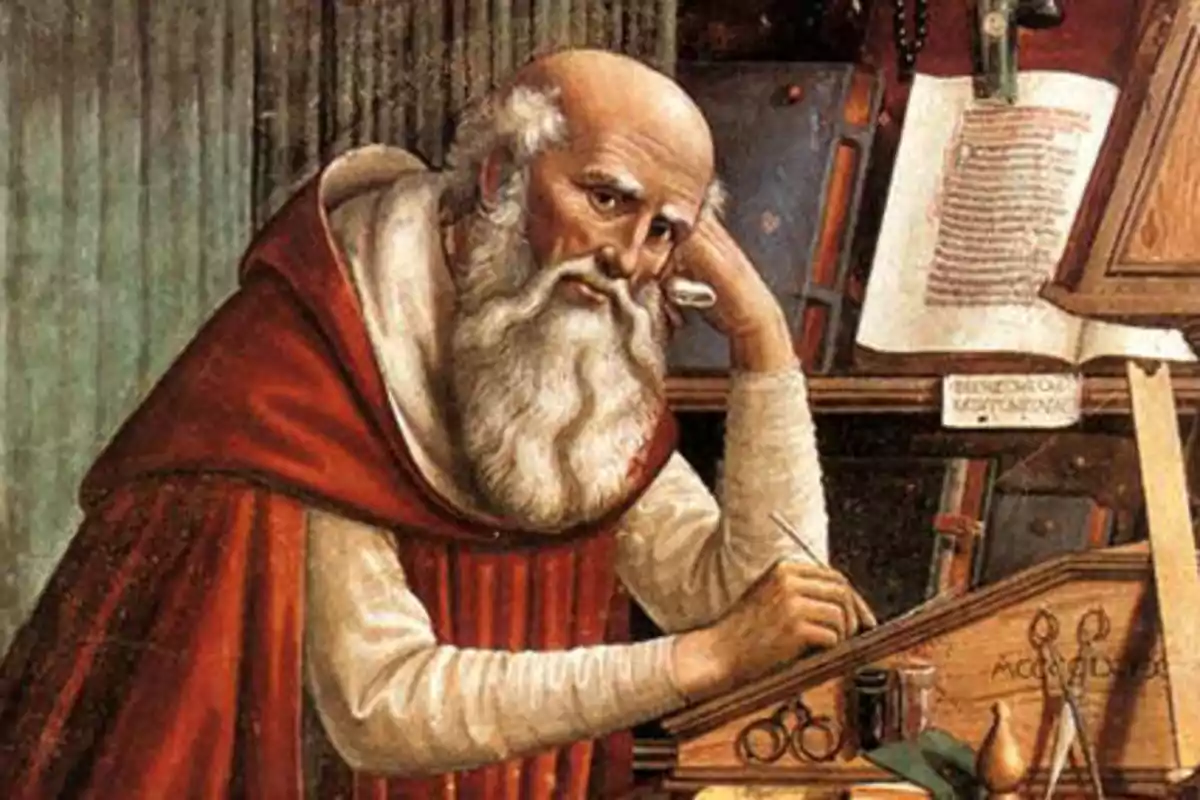 Un hombre mayor con barba blanca y túnica roja escribe en un escritorio rodeado de libros y objetos antiguos