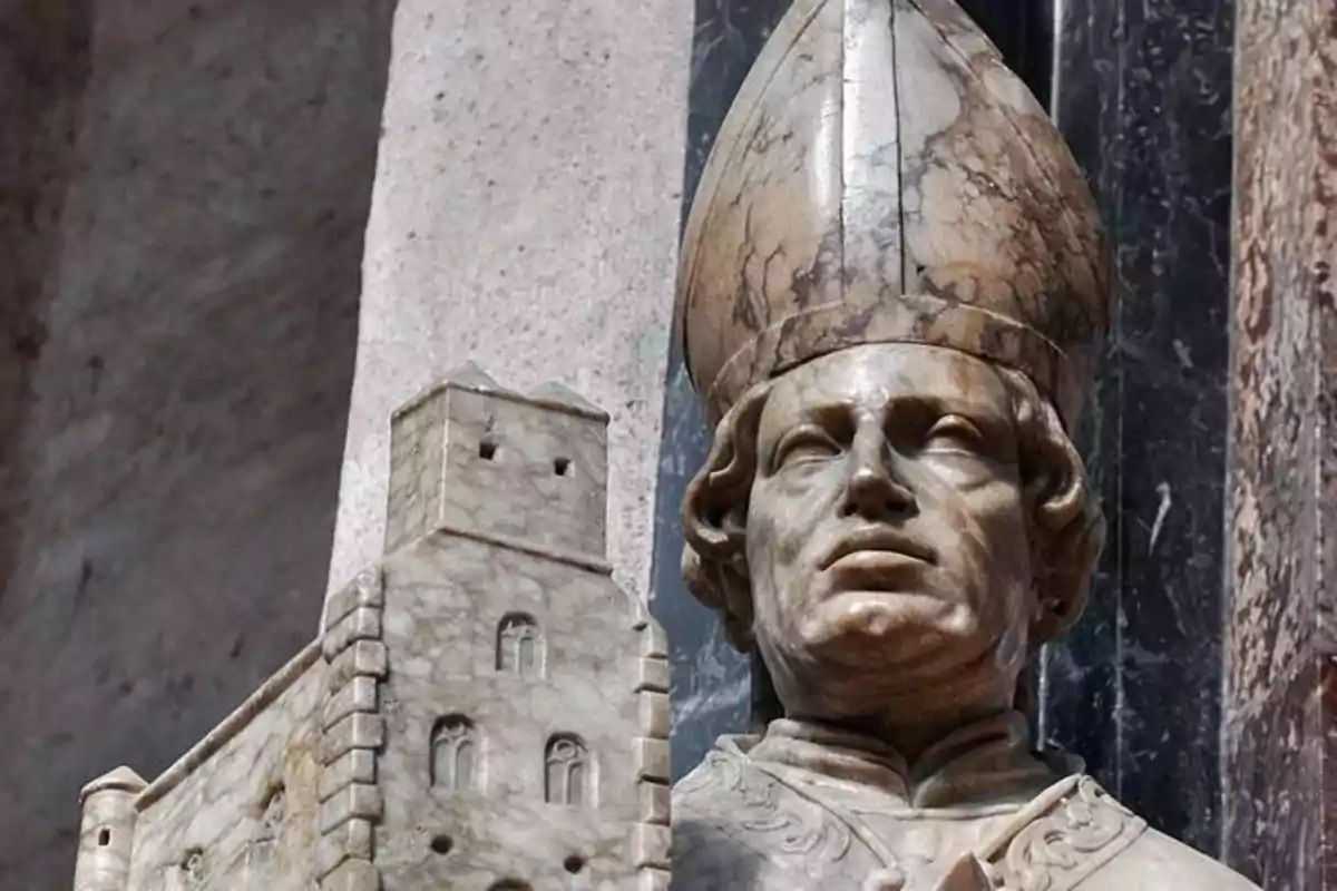 Escultura de un obispo con mitra sosteniendo una maqueta de edificio hecha de mármol. Escultura de un obispo con mitra sosteniendo una maqueta de edificio hecha de mármol.