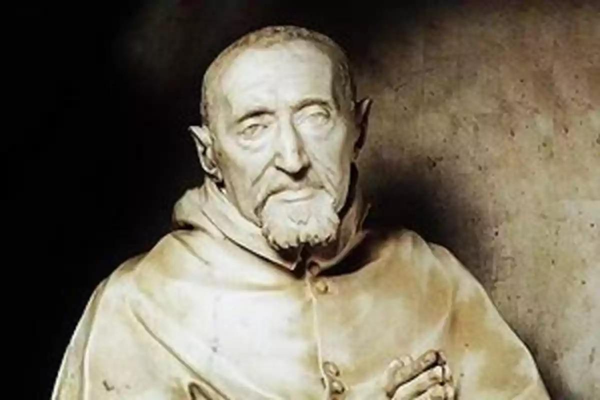 Escultura de un hombre mayor con barba corta y expresión seria vestido con una túnica