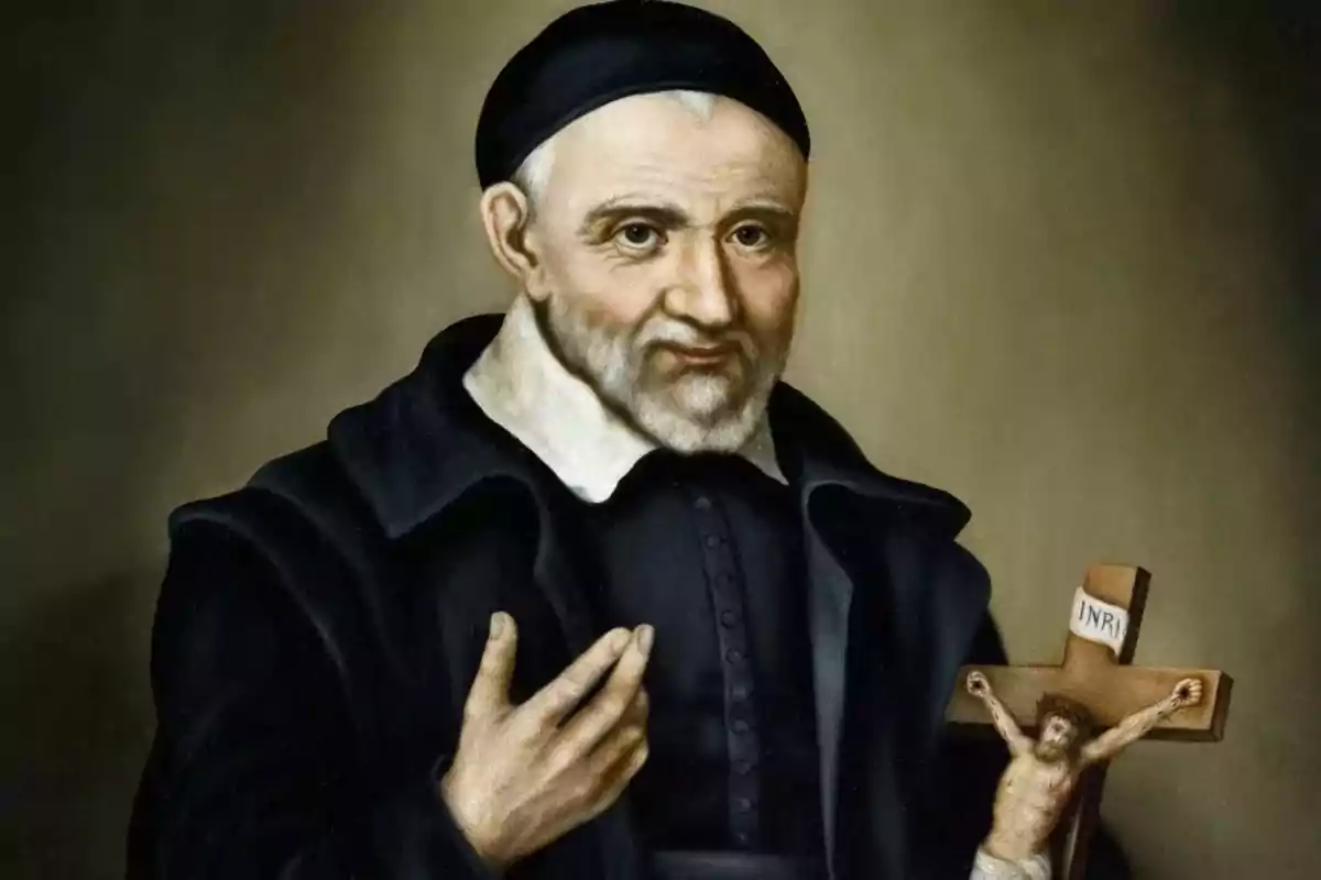 Retrato de un hombre mayor con barba canosa y vestimenta oscura sosteniendo un crucifijo en una mano