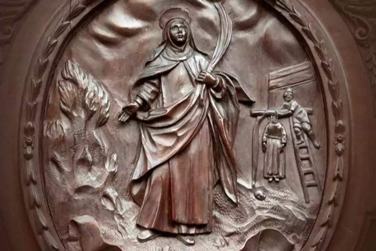 Relieve de madera que muestra a una figura religiosa femenina con halo y palma, junto a una escena de martirio y un árbol en el fondo