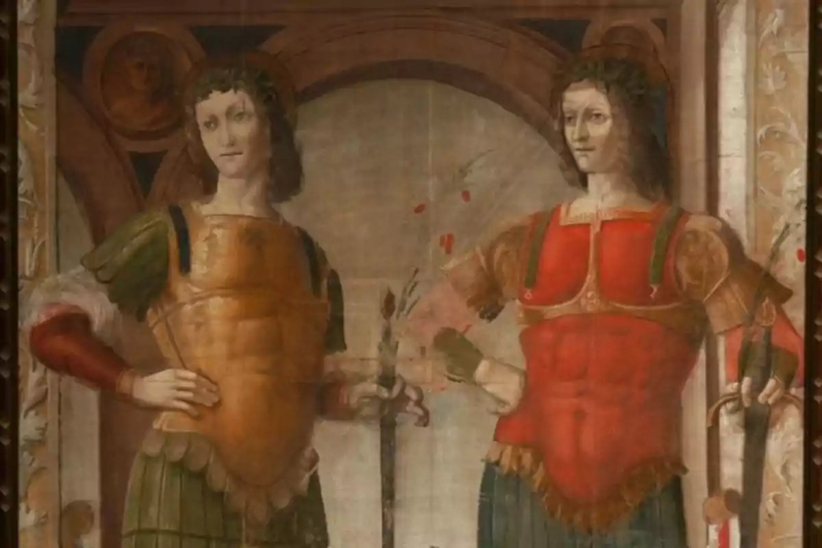 Dues figures masculines amb armadures de colors, una daurada i una altra vermella, posen dretes una al costat de l’altra en una pintura renaixentista. Dues figures masculines amb armadures de colors, una daurada i una altra vermella, posen dretes una al costat de l’altra en una pintura renaixentista.