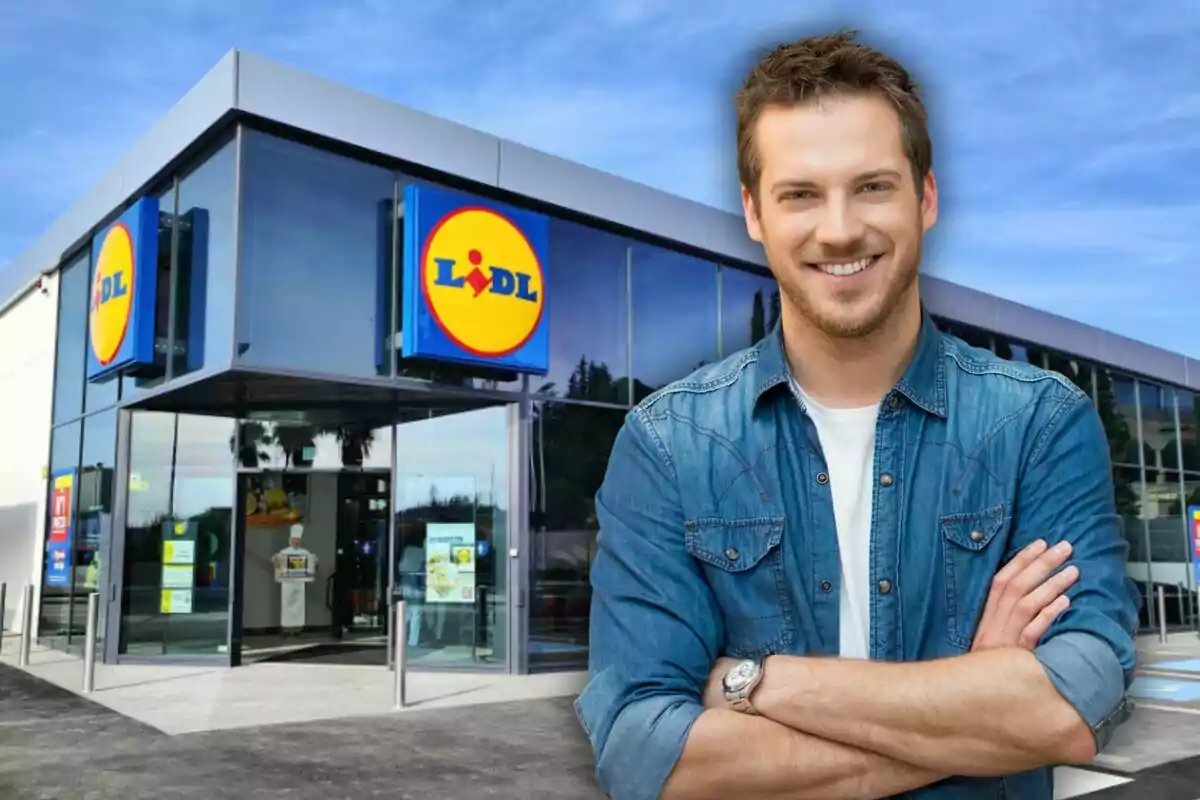 Hombre joven sonriente con camisa de mezclilla de pie frente a una tienda Lidl