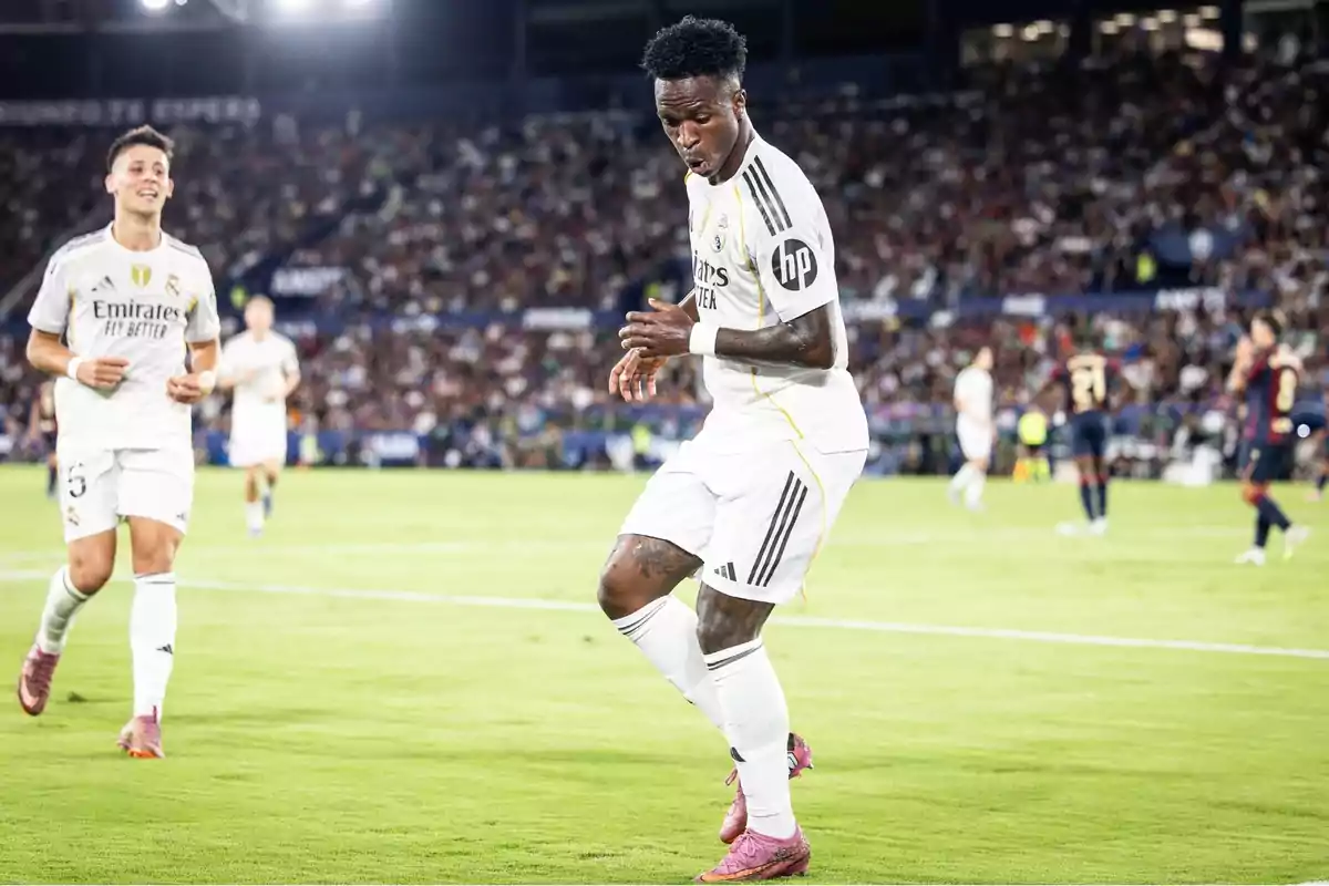 Real Madrid player celebrating a goal in a packed stadium during a night match