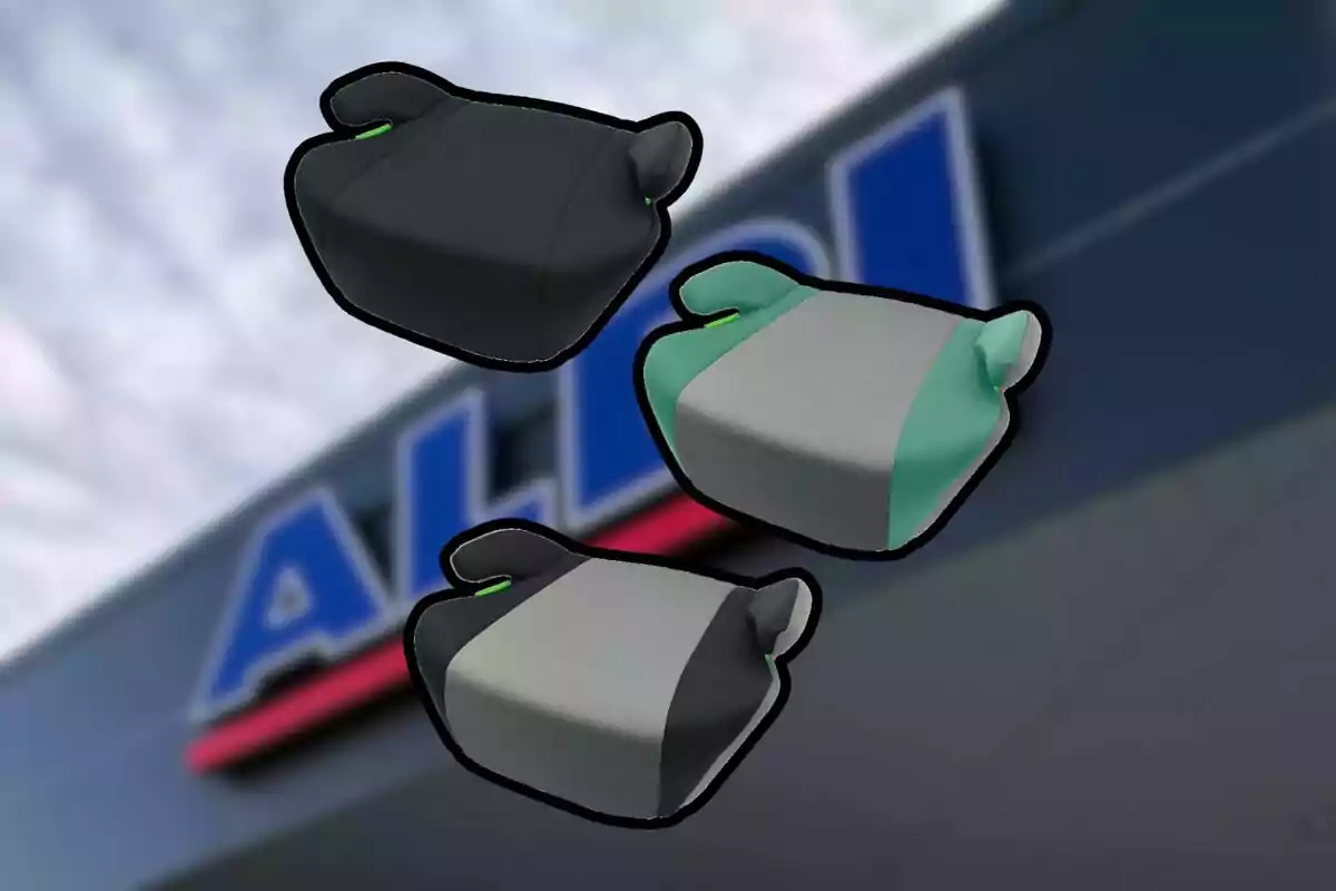 Tres asientos elevadores para niños en diferentes colores sobre un fondo desenfocado de una tienda Aldi