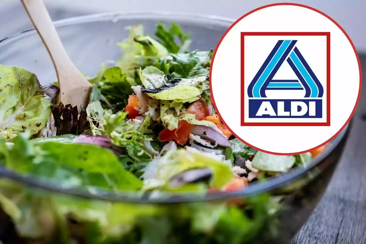 Amanida fresca en un bol de vidre amb una cullera de fusta i el logotip d’ALDI en un cercle superposat