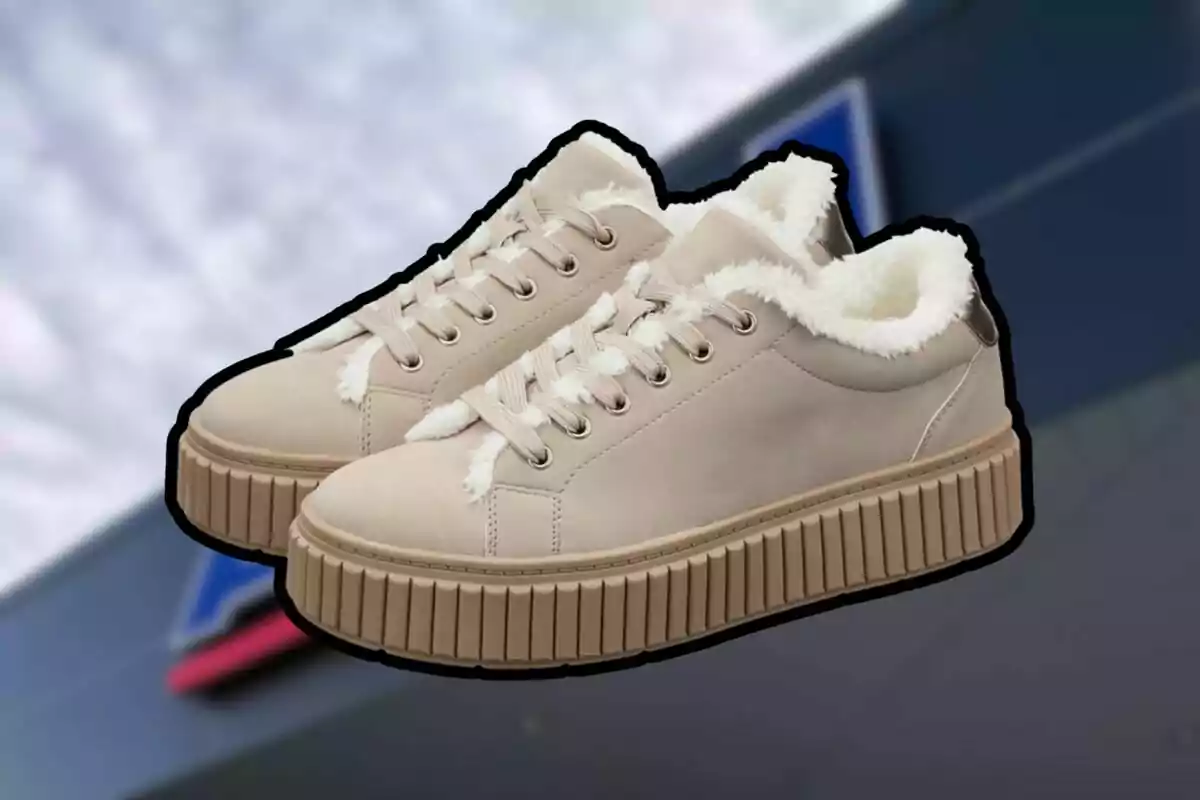 Tenis beige con suela gruesa y forro interior de peluche blanco sobre un fondo desenfocado Tenis beige con suela gruesa y forro interior de peluche blanco sobre un fondo desenfocado
