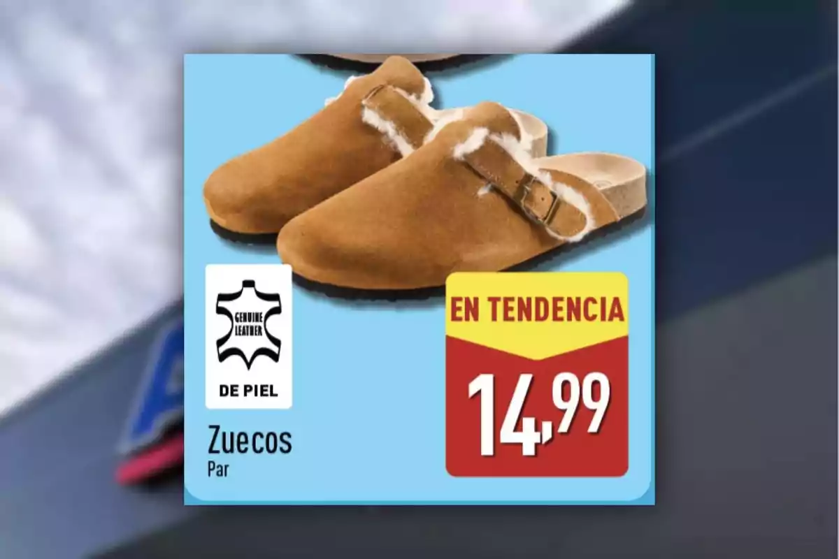 Zuecos de piel color camel con forro blanco y hebilla metálica, etiqueta de genuino cuero, precio de 14,99 y anuncio de en tendencia sobre fondo azul Zuecos de piel color camel con forro blanco y hebilla metálica, etiqueta de genuino cuero, precio de 14,99 y anuncio de en tendencia sobre fondo azul