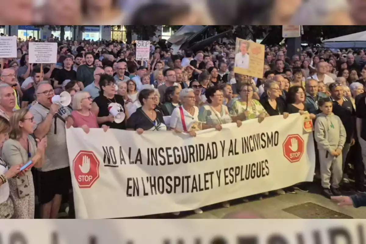 Un grupo numeroso de personas participa en una manifestación sosteniendo una pancarta que expresa su rechazo a la inseguridad y al incivismo en L'Hospitalet y Esplugues