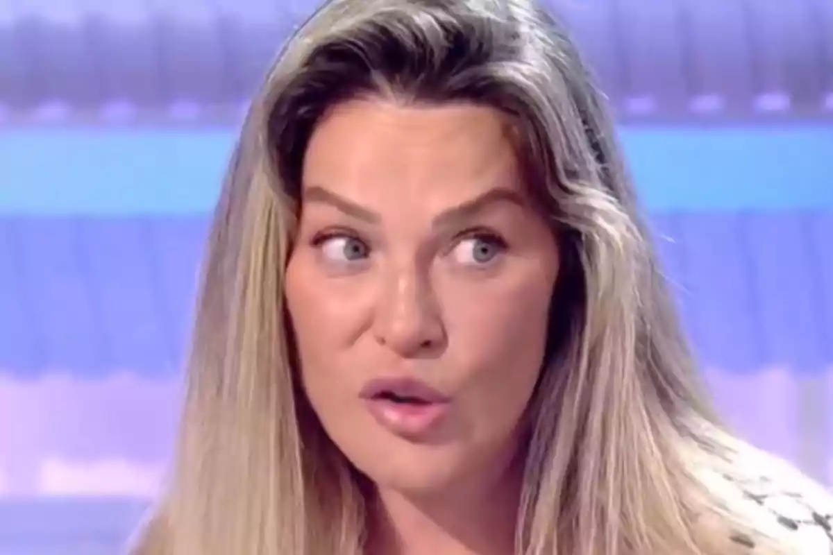 Mujer de cabello rubio largo mirando hacia un lado con expresión de sorpresa