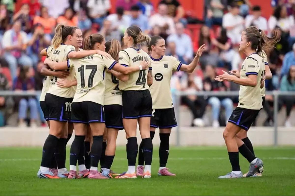 Jugadoras de un equipo de fútbol femenino celebran juntas en el campo durante un partido