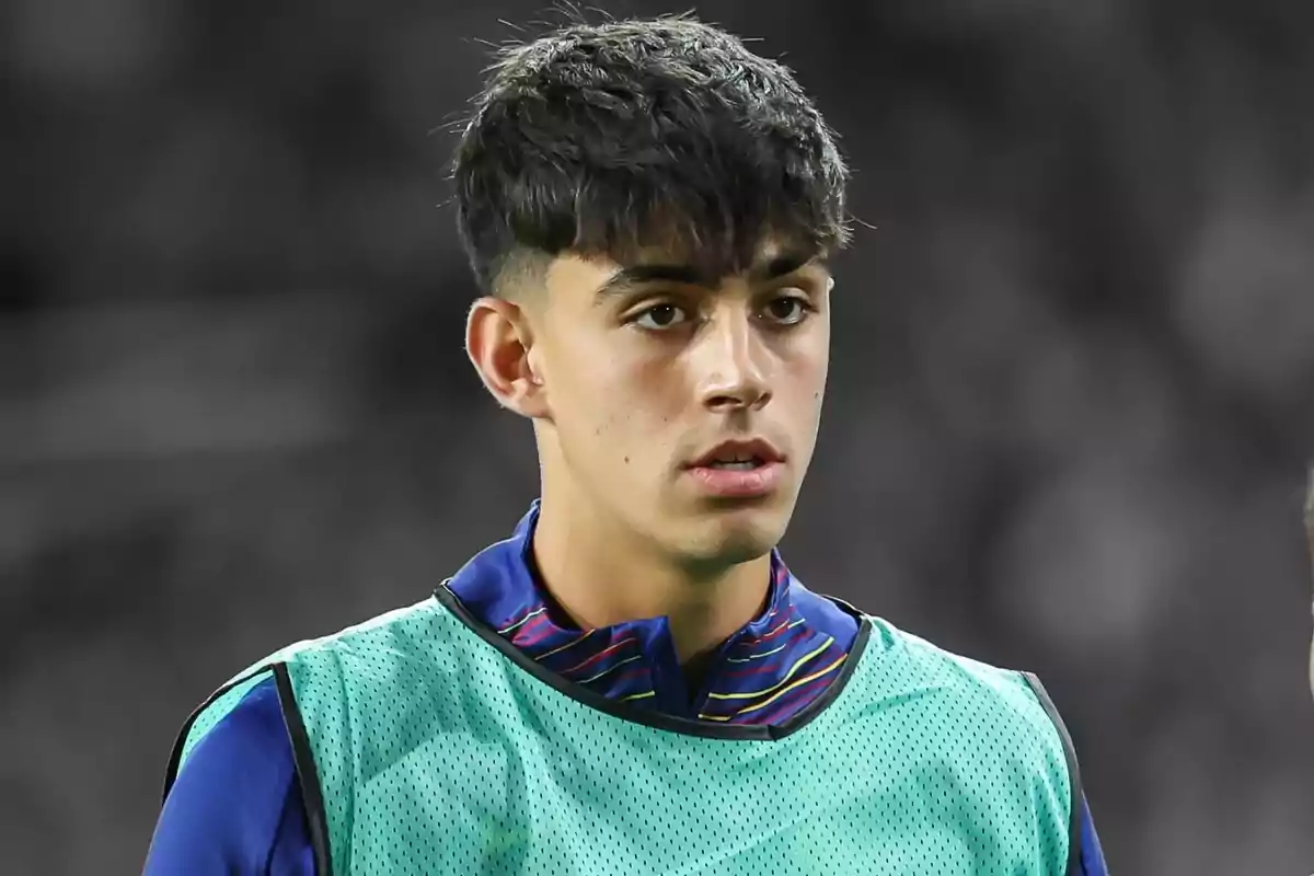 Jove futbolista amb armilla d'entrenament en un estadi