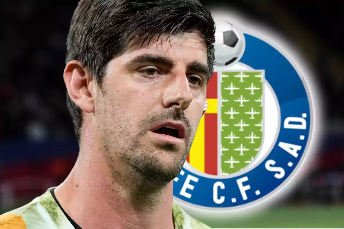 Un portero de fútbol con expresión seria aparece en primer plano con el escudo del Getafe CF de fondo.