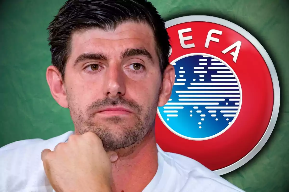 Home de cabells foscos amb expressió seriosa davant d’un logotip de la UEFA sobre fons verd