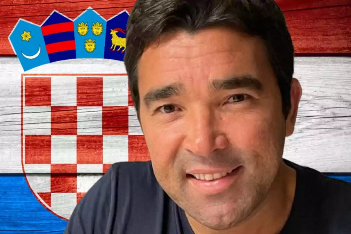 Home somrient davant d’una bandera de Croàcia amb escut