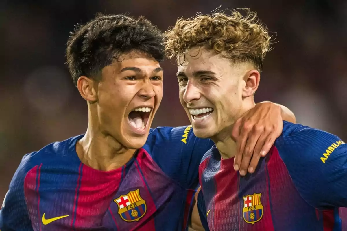 Dos jugadors del Barcelona celebren somrients un gol abraçats al camp
