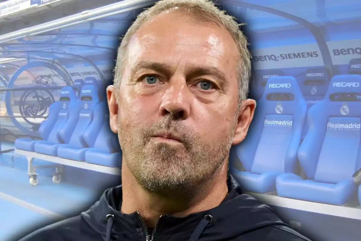 Home de cabell curt i barba amb expressió seriosa davant dels seients blaus de la banqueta d’un estadi de futbol