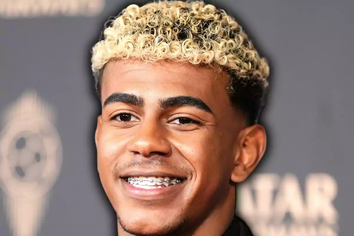 Jove somrient amb brackets i cabell arrissat ros a la part superior