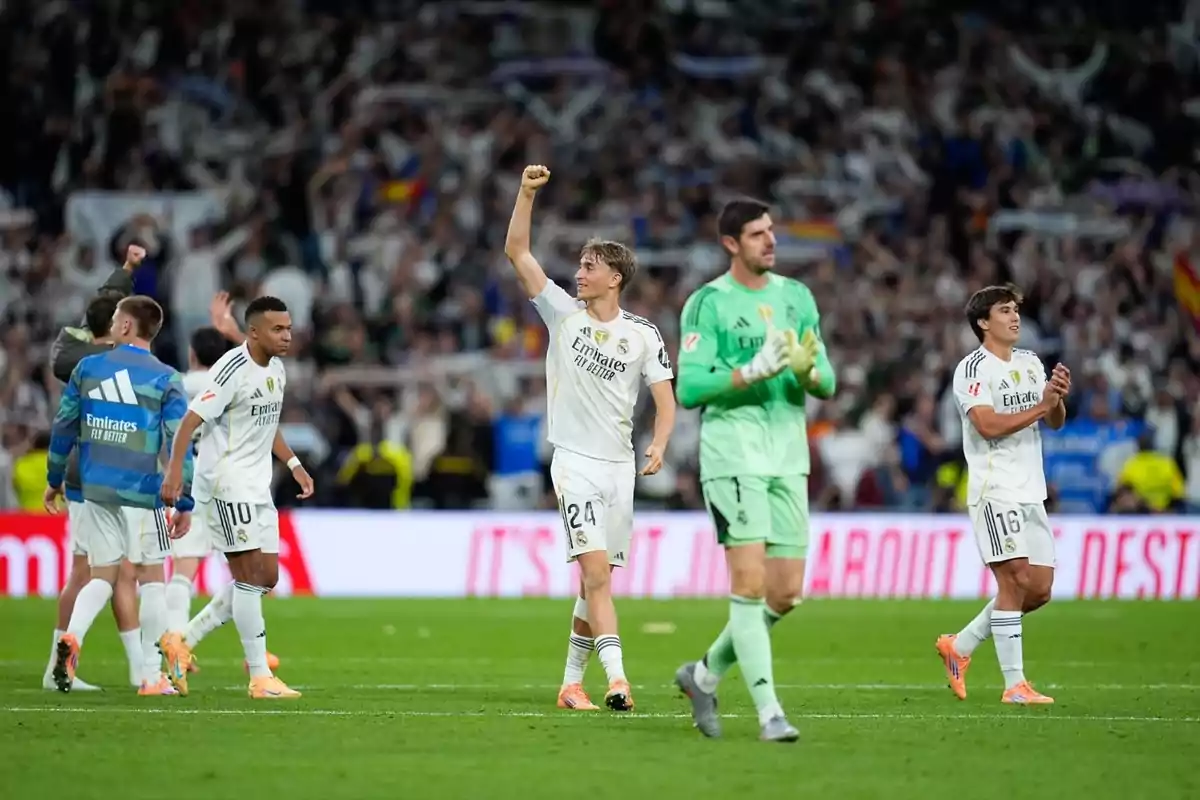 Jugadors del Reial Madrid celebren al camp després d’un partit amb l’afició de fons