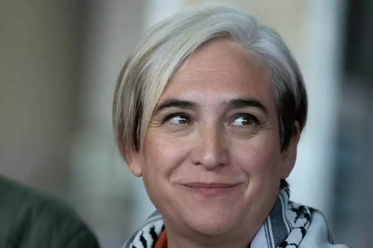 Mujer de cabello corto y canoso sonriendo levemente y mirando hacia un lado Mujer de cabello corto y canoso sonriendo levemente y mirando hacia un lado