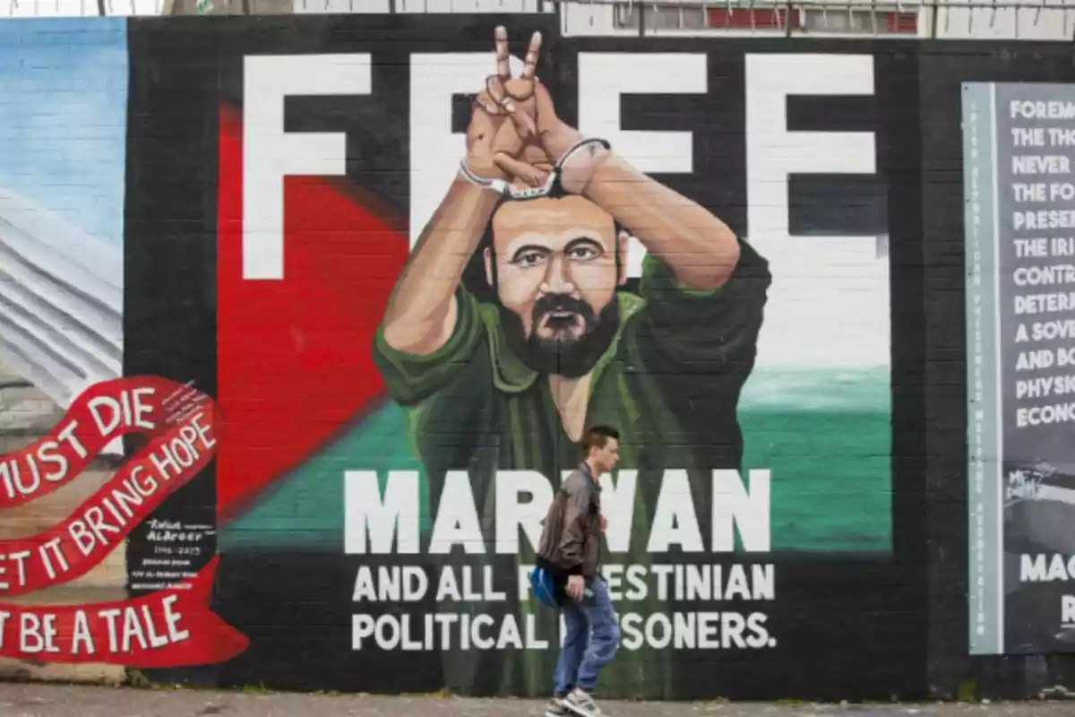 Un home passa al costat d’un mural del líder polític palestí Marwan Barghouti, al Mur Internacional de Belfast, encarregat per Mares Contra el Genocidi i pintat pel muralista Marty Lyons. Un home passa al costat d’un mural del líder polític palestí Marwan Barghouti, al Mur Internacional de Belfast, encarregat per Mares Contra el Genocidi i pintat pel muralista Marty Lyons.