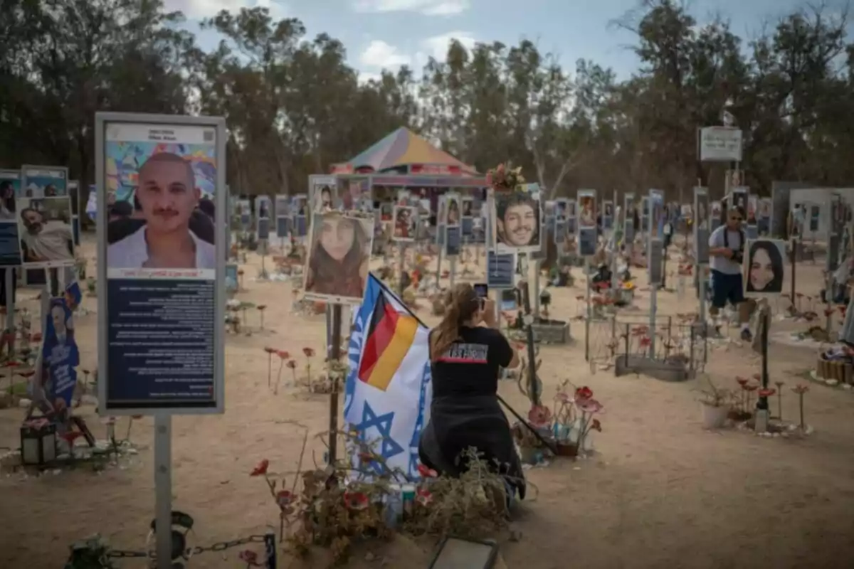 Una dona que sosté una bandera israeliana i una d’alemanya es fa una foto al recinte del festival Nova a Re'im abans del segon aniversari de l’atac del 7 d’octubre liderat per Hamàs.