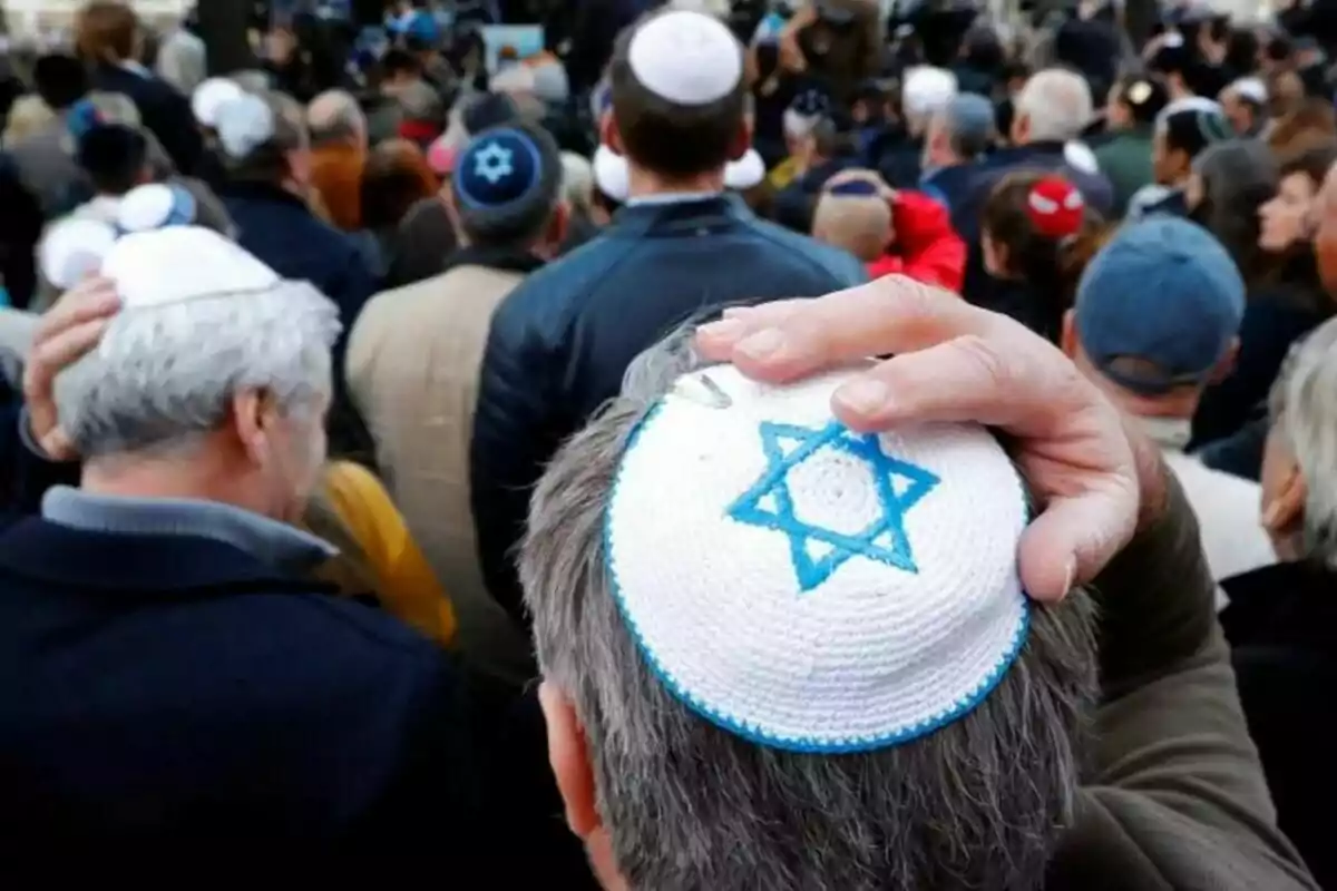 Un grup de persones reunides, moltes d'elles amb kipàs, una de les quals en porta una amb una estrella de David blava teixida.