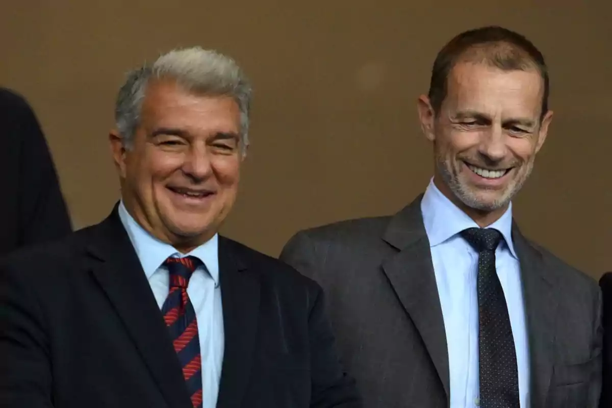 Dos hombres de traje sonríen mientras posan juntos en un evento formal Dos hombres de traje sonríen mientras posan juntos en un evento formal