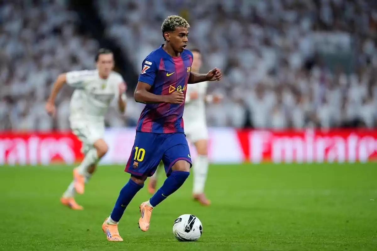 Jugador del Barcelona amb el número 10 a l’uniforme corre amb la pilota durant un partit de futbol contra un equip vestit de blanc