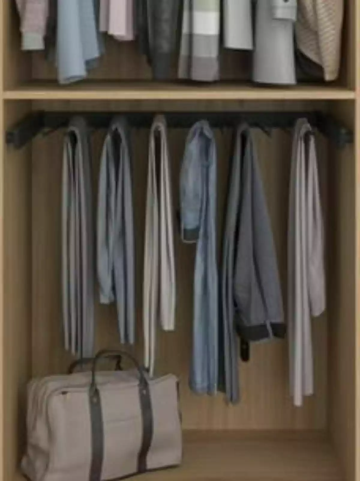 Un armari de fusta amb roba penjada i una bossa de viatge a la part inferior