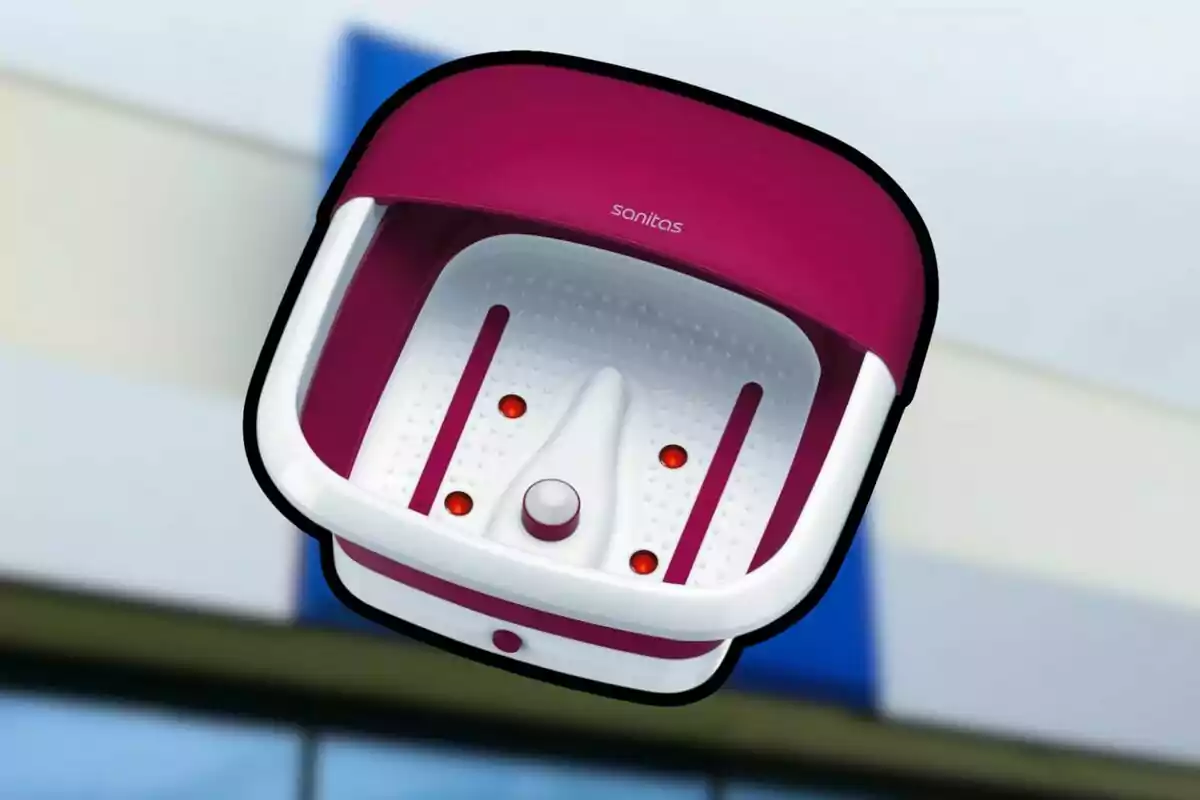 Banyera d’hidromassatge per a peus de color blanc i rosa amb llums vermelles a l’interior i la marca Sanitas a la part superior