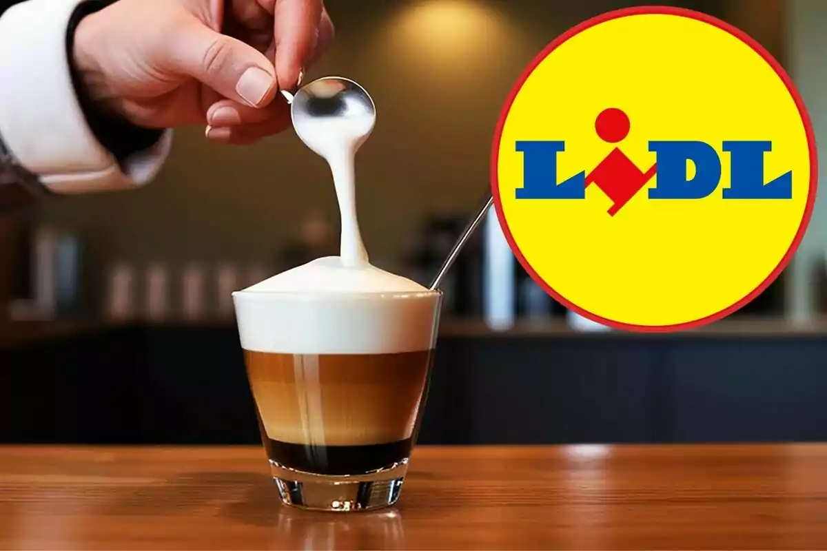 Una mano sostiene una cuchara con espuma de leche sobre un café en vaso de cristal y al lado aparece el logotipo de Lidl Una mano sostiene una cuchara con espuma de leche sobre un café en vaso de cristal y al lado aparece el logotipo de Lidl