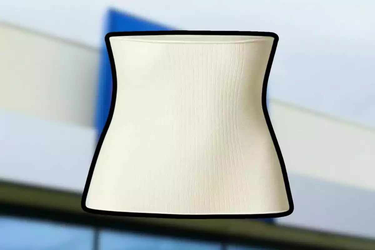 Pantalla de lámpara beige con borde negro sobre un fondo desenfocado