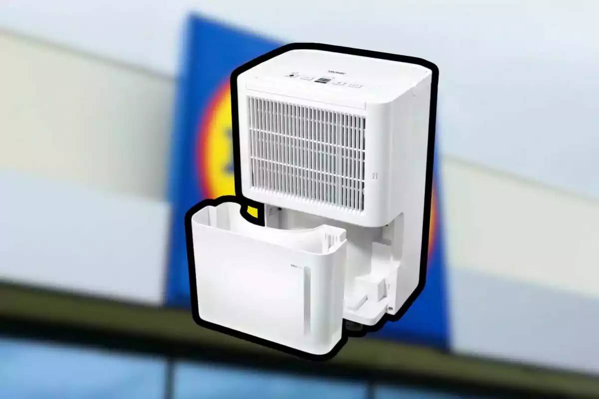 Deshumidificador blanco con depósito extraíble frente a un fondo desenfocado de una tienda Deshumidificador blanco con depósito extraíble frente a un fondo desenfocado de una tienda