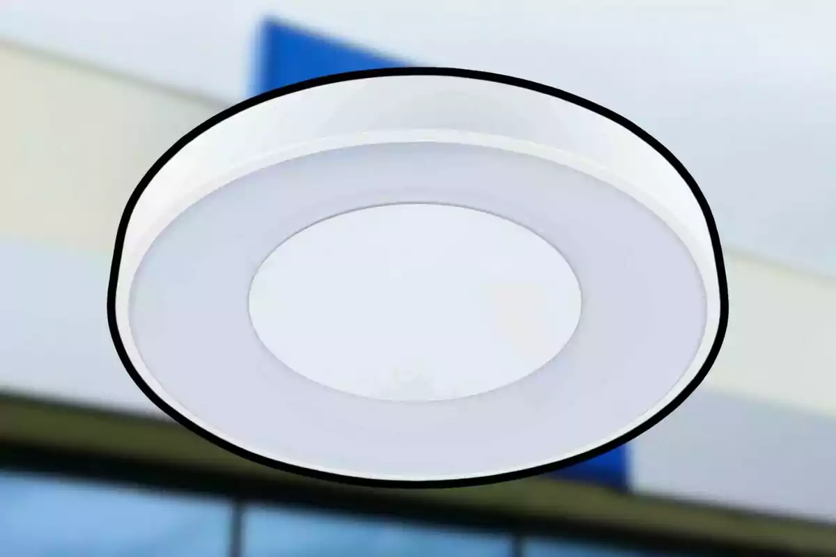 Lámpara de techo circular blanca con fondo desenfocado de edificio