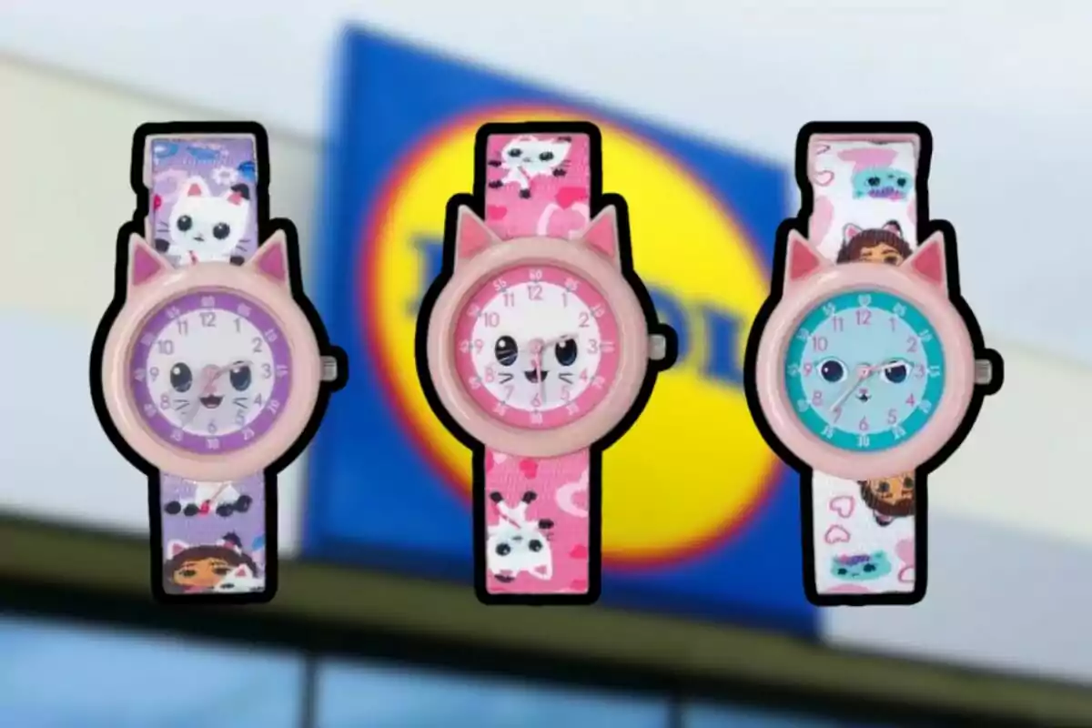 Tres relojes infantiles con diseño de gato y correas coloridas están frente a un letrero borroso de una tienda