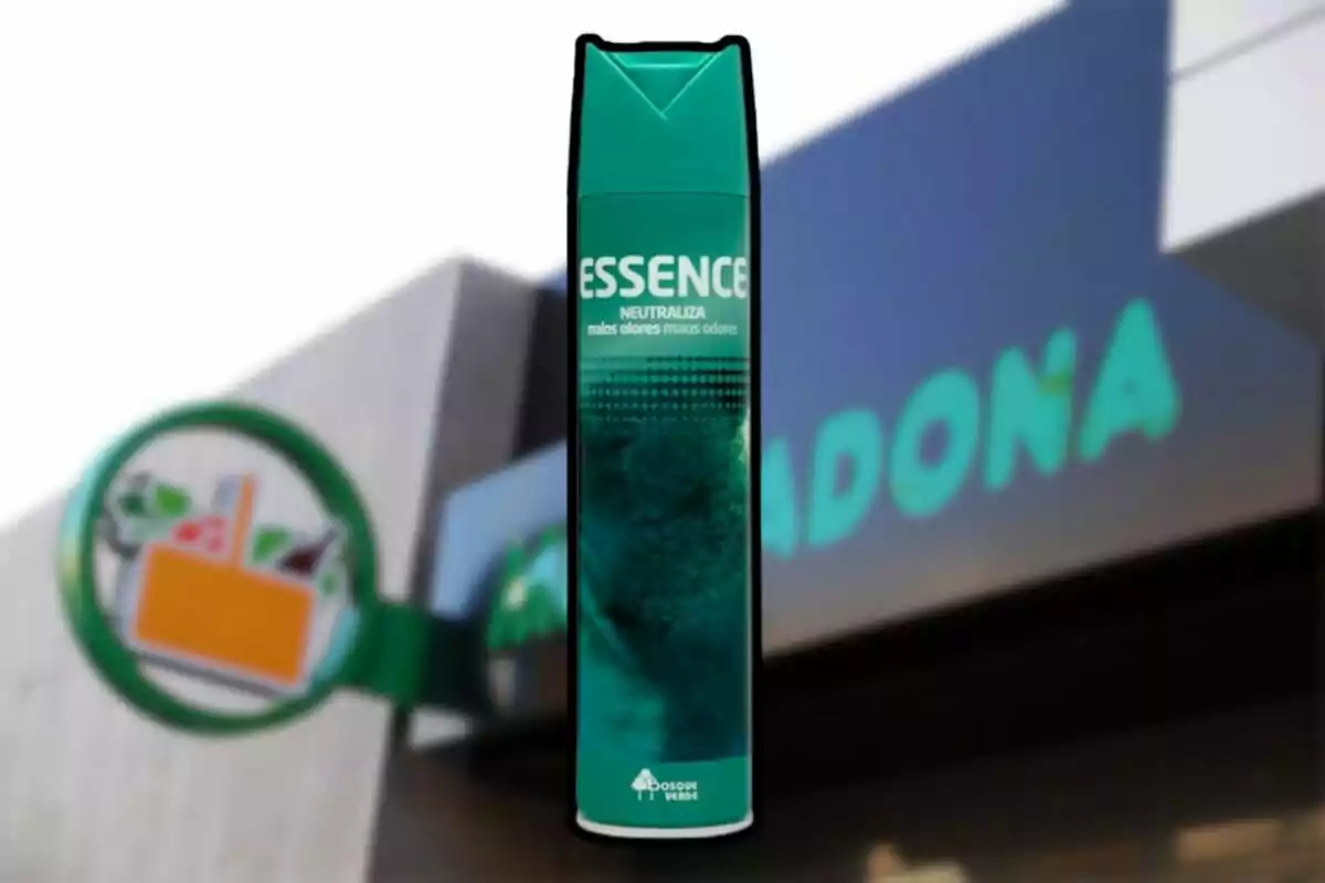 Ambientador en aerosol de la marca Essence frente a una tienda de supermercado desenfocada Ambientador en aerosol de la marca Essence frente a una tienda de supermercado desenfocada