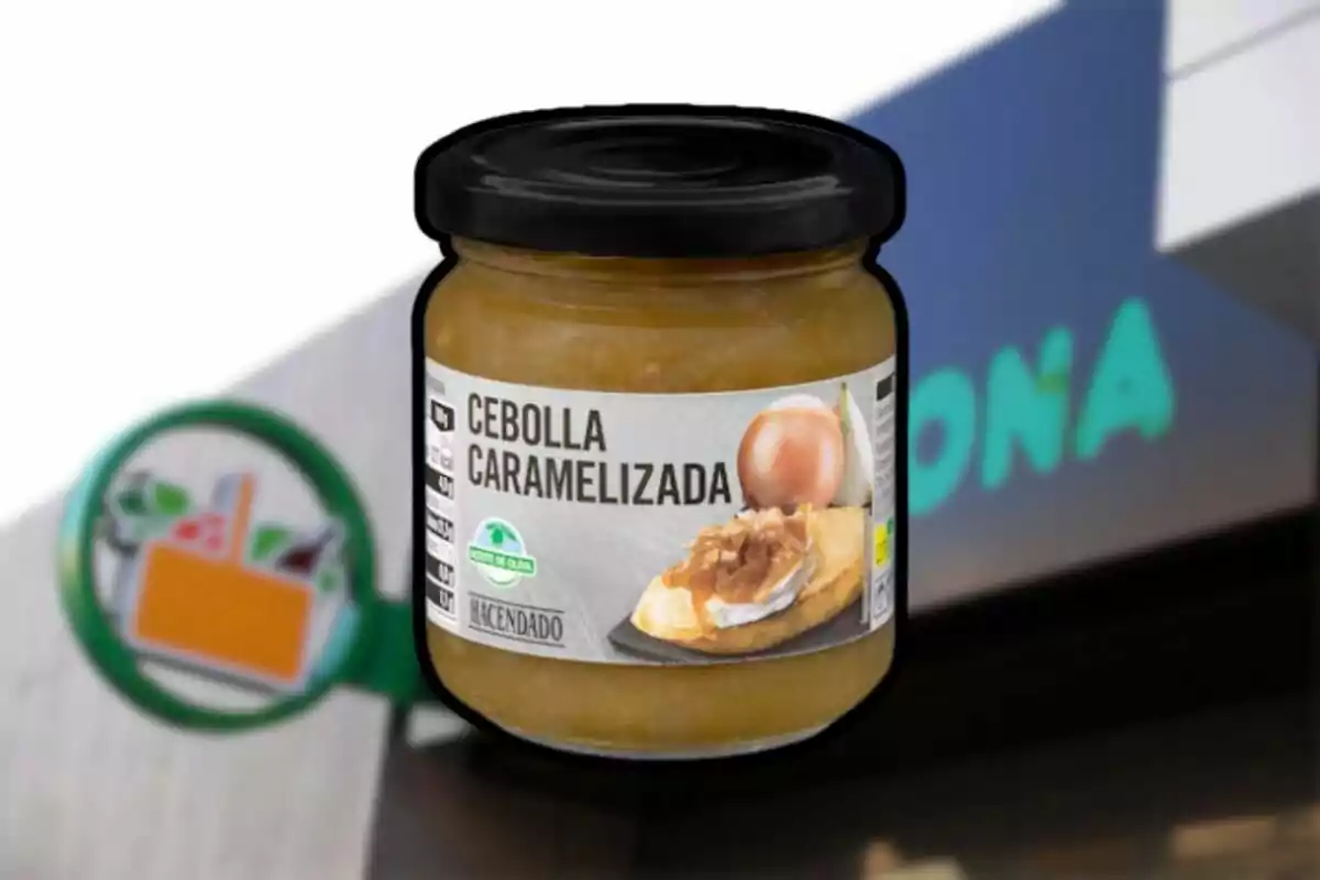 Frasco de cebolla caramelizada de la marca Hacendado frente a una tienda Mercadona desenfocada.