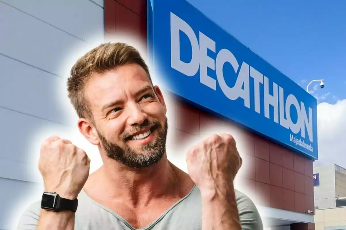Home somrient amb els punys alçats davant d'una botiga Decathlon.