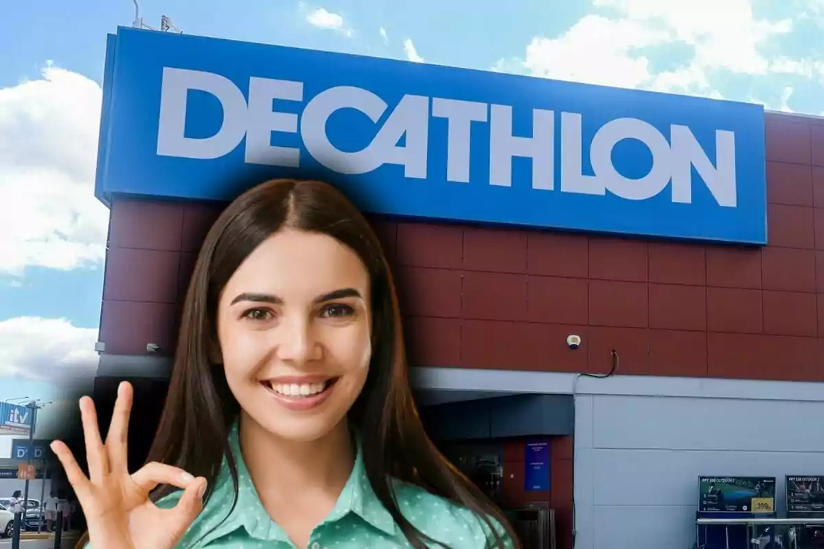 Una dona somrient fa el gest de 'ok' amb la mà davant d'una botiga Decathlon.