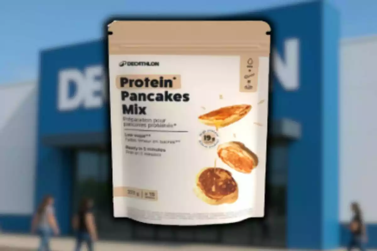 Barreja de pancakes proteics de Decathlon en un embolcall beix davant d’una botiga amb persones caminant.