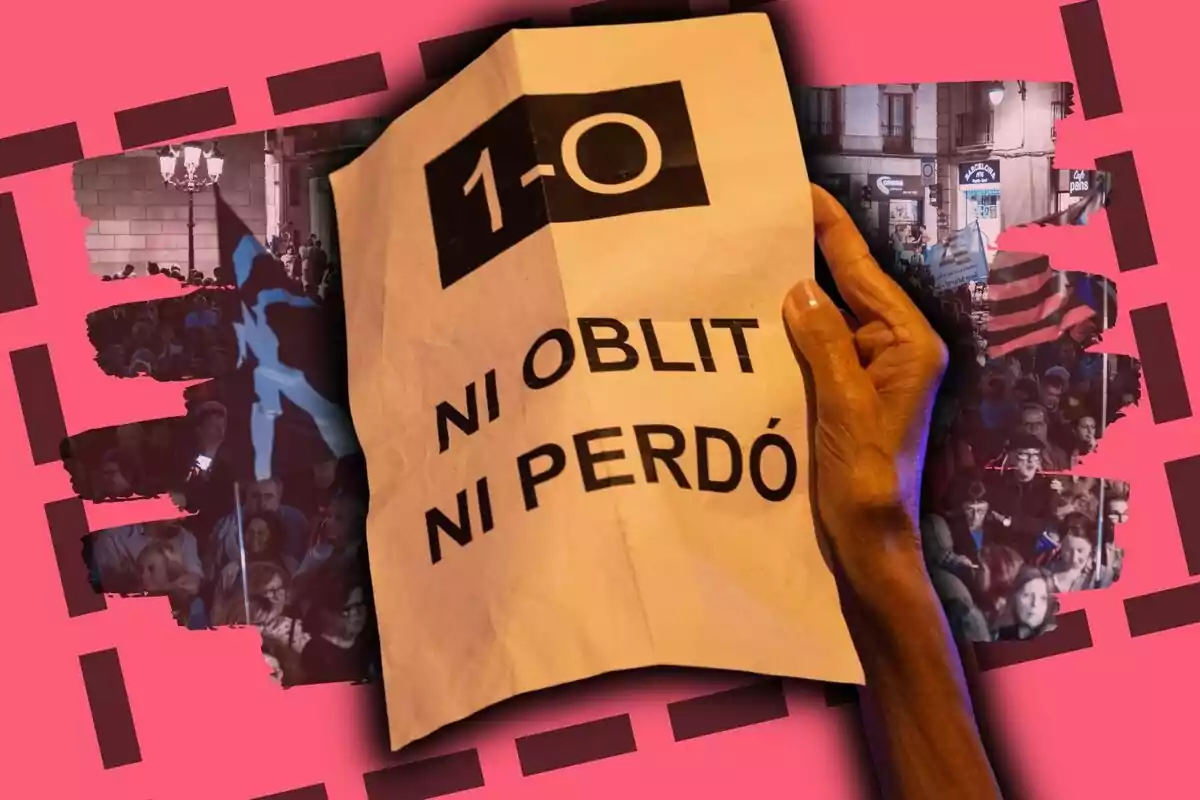 Una mà sosté un cartell arrugat amb el text 1-O ni oblit ni perdó sobre un fons de manifestants i banderes en tons vermellosos.