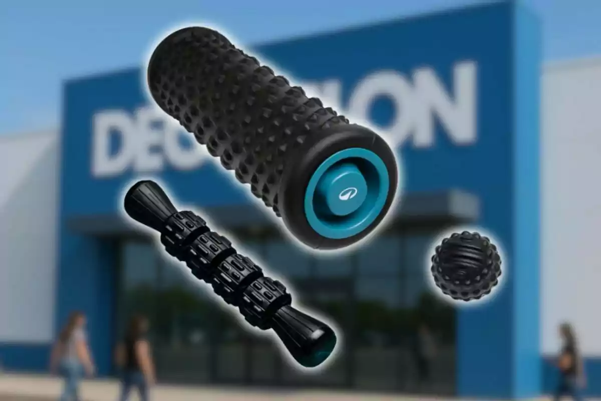 Davant d’una botiga d’esports es mostren tres productes de massatge muscular de color negre i blau de Decathlon, incloent-hi un corró, un pal de massatge i una pilota texturitzada.