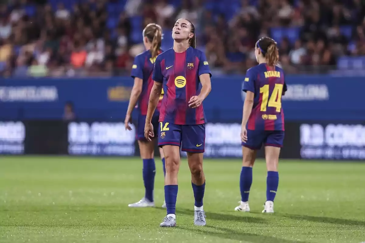 Jugadores de l’equip femení del Barcelona al camp durant un partit amb expressió seriosa i uniforme blaugrana