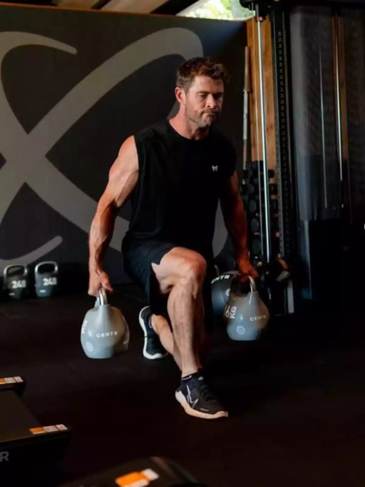 Chris Hemsworth fent exercicis de gambades amb peses russes en un gimnàs Chris Hemsworth fent exercicis de gambades amb peses russes en un gimnàs