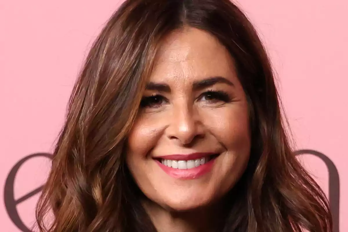 Nuria Roca somrient davant d’un fons rosa