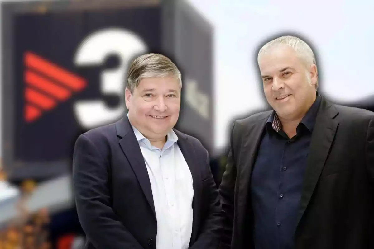 Dos hombres con traje posan sonrientes frente a un fondo desenfocado con el logotipo de TV3