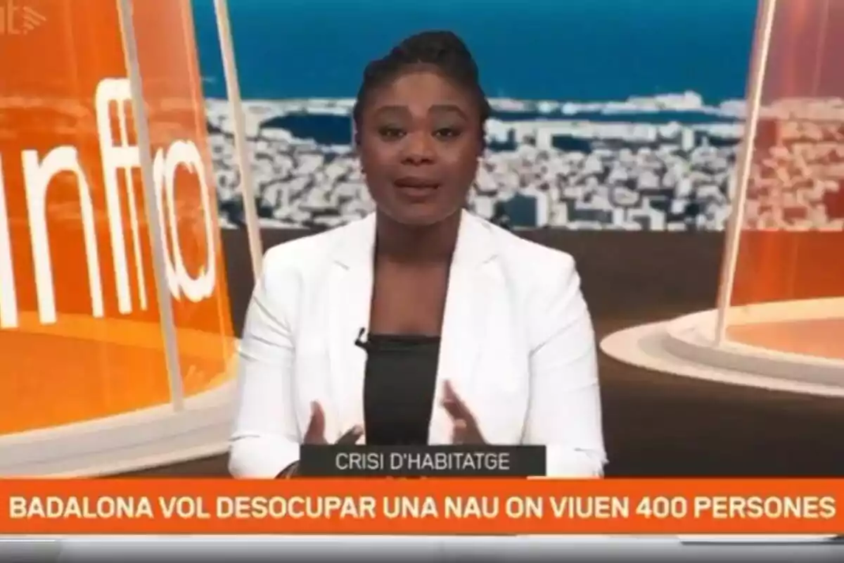Presentadora de noticias en un estudio con un rótulo que informa sobre la intención de Badalona de desalojar una nave donde viven 400 personas