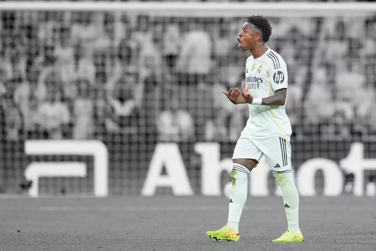 Futbolista amb uniforme blanc gesticulant al camp davant d’una porteria desenfocada Futbolista amb uniforme blanc gesticulant al camp davant d’una porteria desenfocada